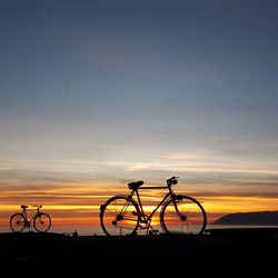 Silhouette bicycle against sky during sunset