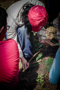 Rear view of people holding red umbrella