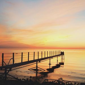 Pier on sea at sunset