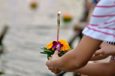 Cropped hands holding religious offerings