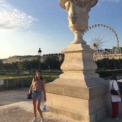 Full length of woman with sculpture against sky