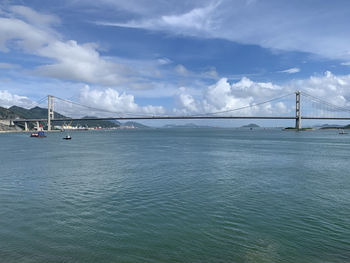 View of suspension bridge over sea against sky