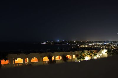 Illuminated city against sky at night