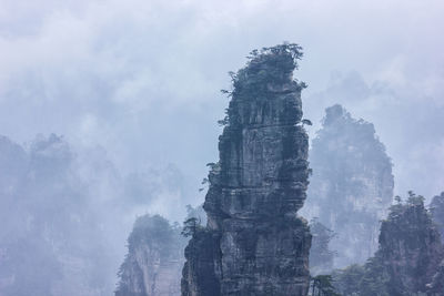 Low angle view of rock formation against cloudy sky