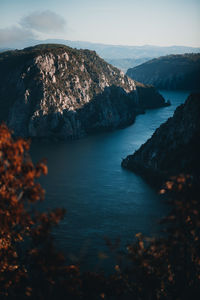 High angle view of sea and mountains against sky