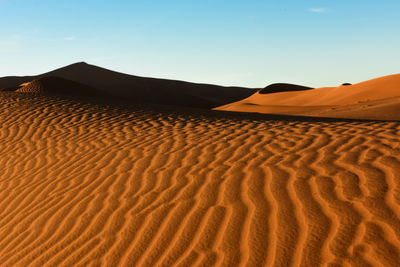 Sand dunes in desert against clear sky