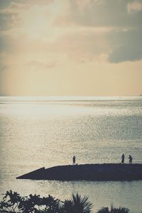 Silhouette man on beach against sky during sunset