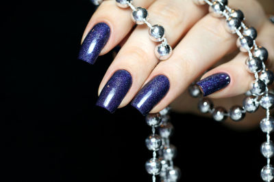 Close-up of woman hand over black background