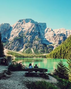 Rear view of people sitting on mountain