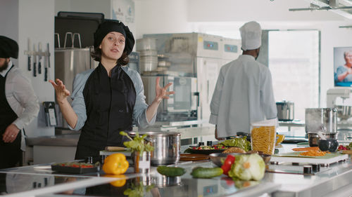 Female chef gesturing in commercial kitchen