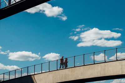 Low angle view of person against cloudy sky