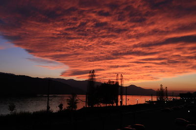 Scenic view of dramatic sky over lake during sunset