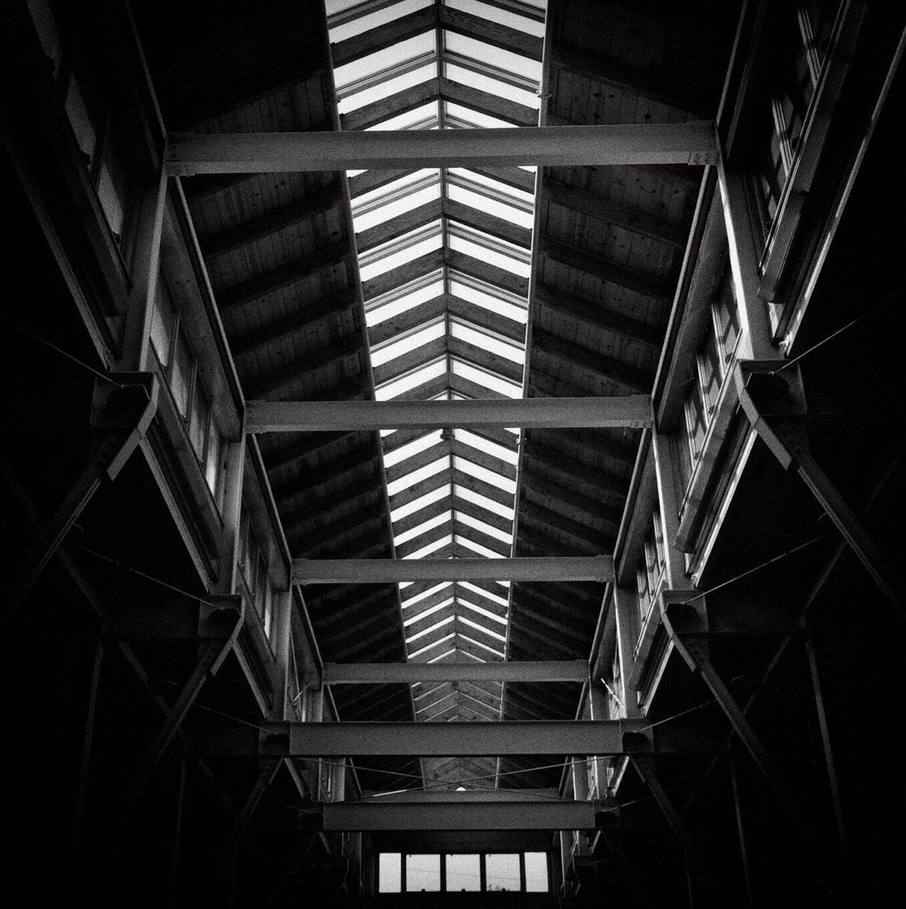 indoors, architecture, built structure, ceiling, low angle view, pattern, railing, illuminated, building, metal, diminishing perspective, no people, lighting equipment, architectural feature, window, design, repetition, the way forward, staircase, interior