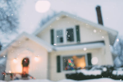 Illuminated building seen through glass window during winter