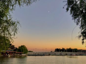 Boats in river at sunset