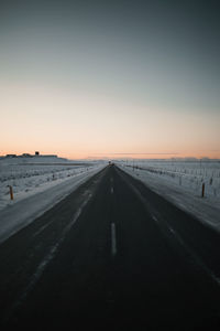 Empty road against clear sky during sunset