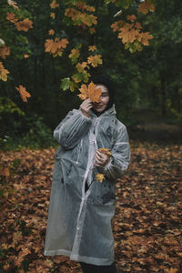Portrait of young woman standing in forest