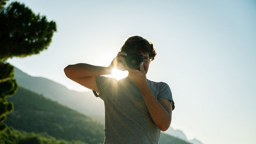 Young man standing against sky