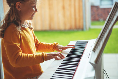 Midsection of woman playing piano