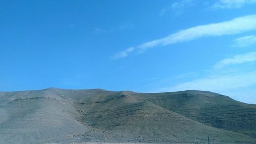 Scenic view of mountains against blue sky