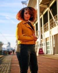 Portrait of young woman standing in city