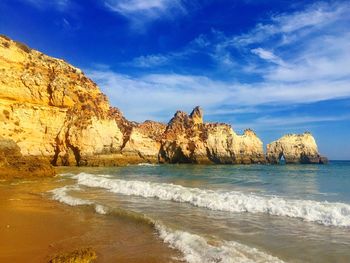 Rock formations by sea against sky