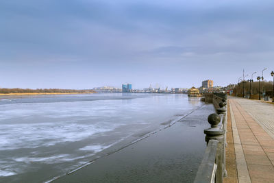 Scenic view of beach by buildings against sky