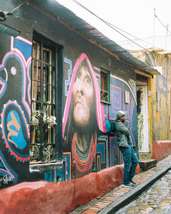 Full length portrait of man standing by building
