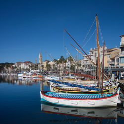 Sailboats moored in harbor