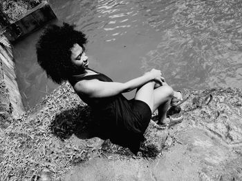 High angle view of woman sitting by water