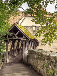 Bridge amidst trees and house in forest