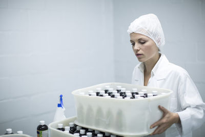 Woman carrying box of medical supplies in medical factory