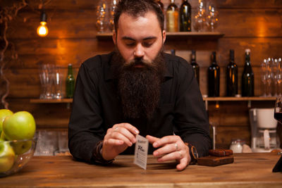 Portrait of young man using mobile phone at table