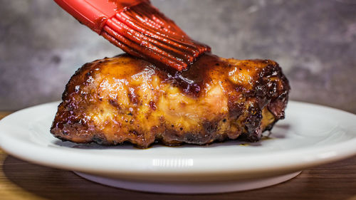 Close-up of chicken getting sauced