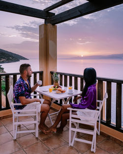 People sitting on table at restaurant against the sky