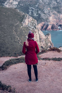 Rear view of woman standing on rock