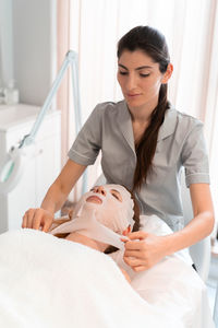Portrait of young woman sleeping on bed at home