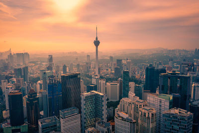 Aerial view of buildings in city during sunset