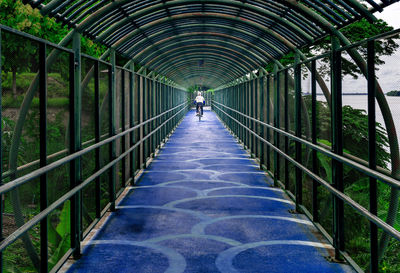 Rear view of man walking on footbridge