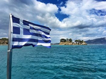Greek flag at sea against sky