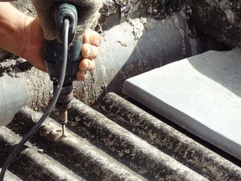 Carpenter using drill on roof