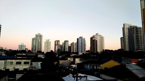 Buildings in city against clear sky