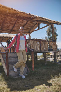 Young tourist comes out of a wooden cabin with a view of the mountain. hiking concept