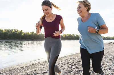 Granddaughter and grandmother having fun, jogging together at the river