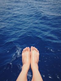 Low section of woman against water