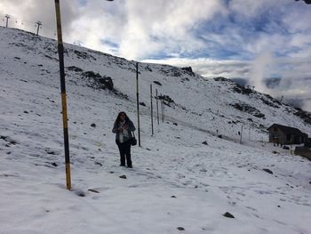 Woman standing on snow covered landscape