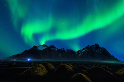 Scenic view of mountains against aurora borealis at night