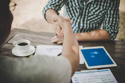 Close-up of business colleagues shaking hands outdoors