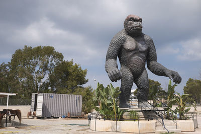 Statue against trees and plants against sky
