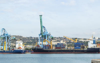 Commercial dock by sea against sky